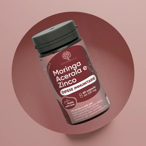 Primo piano del flacone RedMoringa Difese Immunitarie con Moringa, Acerola e Zinco. Confezione da 60 capsule da 535 mg su sfondo circolare bordeaux e rosa.